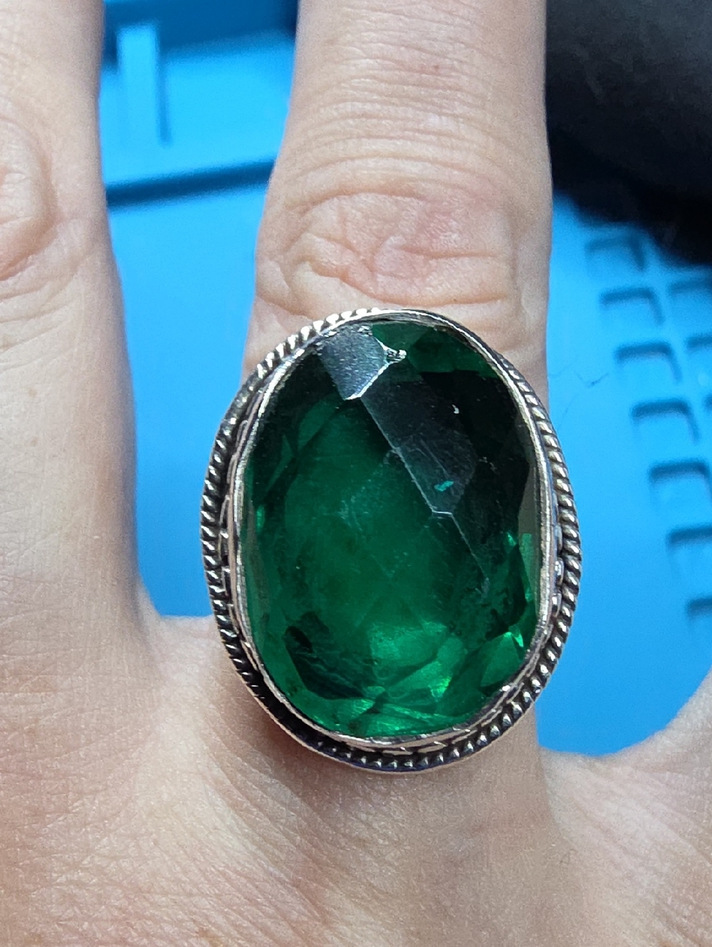 The ring features a large, oval-faceted green gemstone set in a 925 sterling